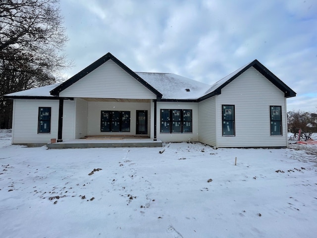 view of snow covered rear of property