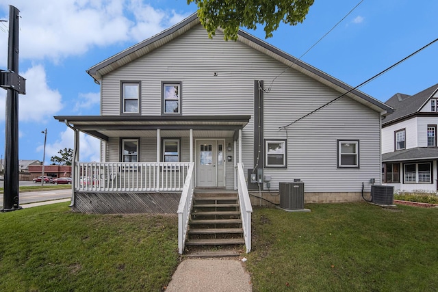 view of front of home featuring a front yard, a porch, and central AC unit