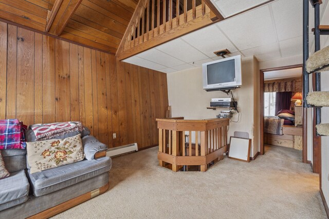 interior space featuring wooden walls, carpet floors, and a baseboard radiator