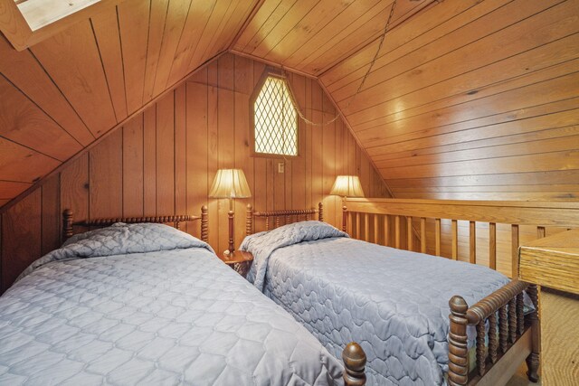 bedroom featuring wooden walls, wooden ceiling, and vaulted ceiling