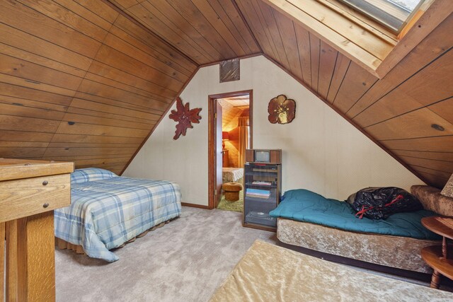 carpeted bedroom featuring vaulted ceiling with skylight and wooden ceiling