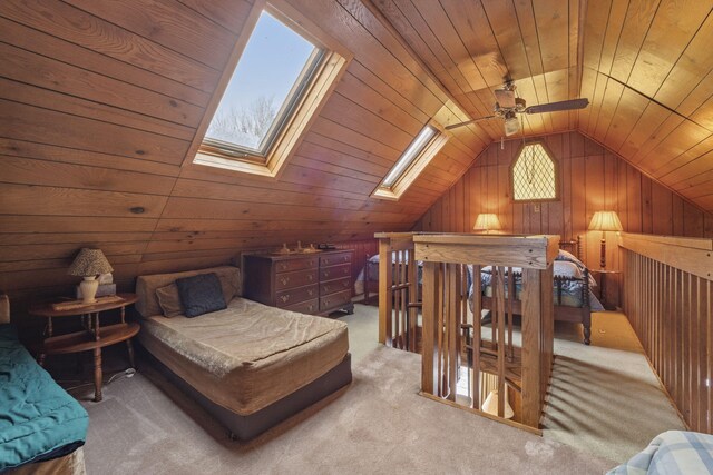 carpeted bedroom with wood walls, vaulted ceiling with skylight, and wooden ceiling