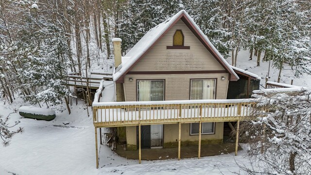 snow covered house featuring a deck