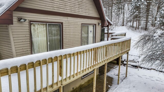 view of snowy exterior with a wooden deck