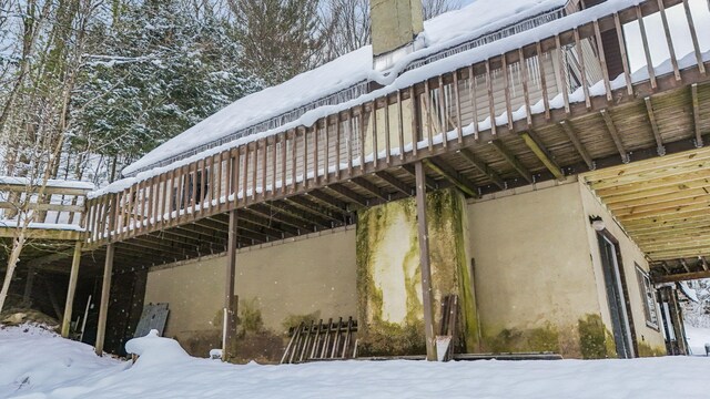 view of snowy exterior with a deck