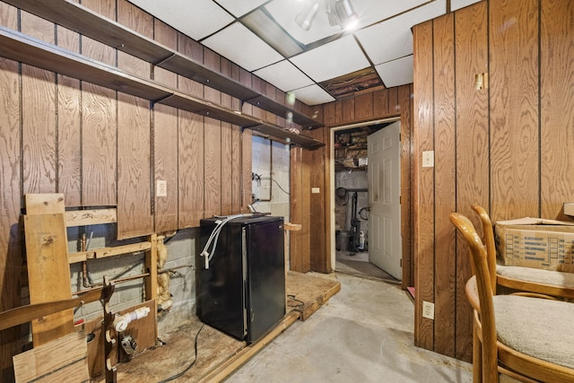 basement with wooden walls and a drop ceiling