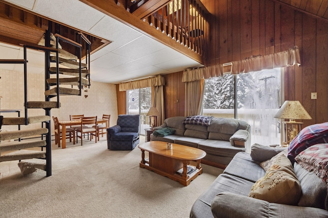 carpeted living room featuring wooden walls and vaulted ceiling