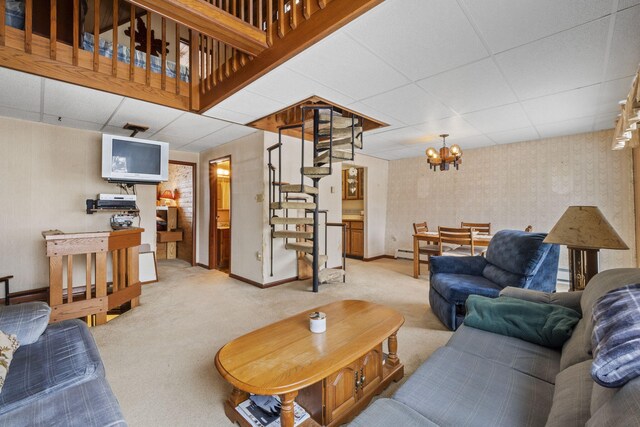 carpeted living room featuring a paneled ceiling, a notable chandelier, and a baseboard heating unit