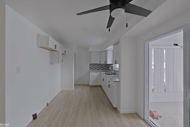 kitchen featuring tasteful backsplash, white cabinetry, and light hardwood / wood-style flooring