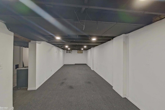 basement featuring dark carpet