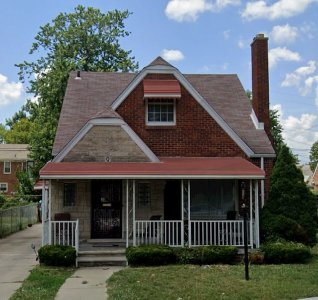 view of front of house with covered porch and a front lawn