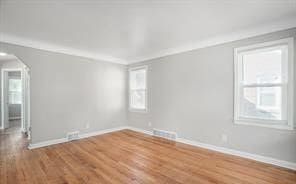 unfurnished room with wood-type flooring and crown molding