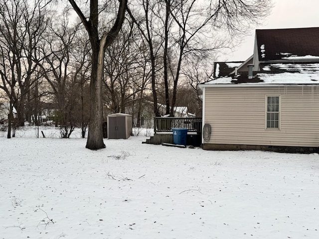 yard covered in snow with a storage shed