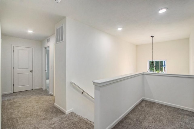 hallway with recessed lighting, carpet, baseboards, and an upstairs landing