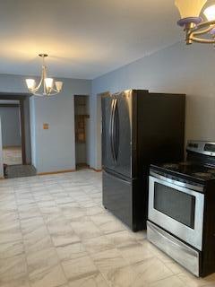 kitchen with hanging light fixtures, appliances with stainless steel finishes, and a chandelier