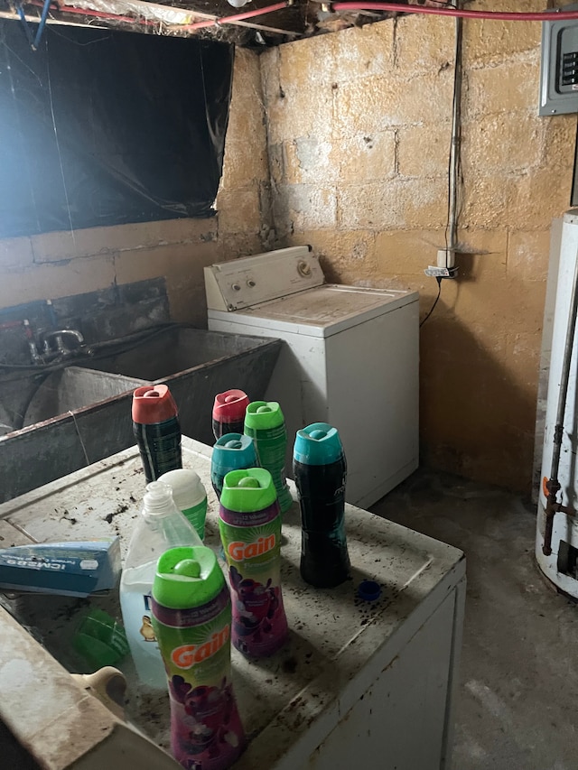 clothes washing area featuring washer / clothes dryer and water heater