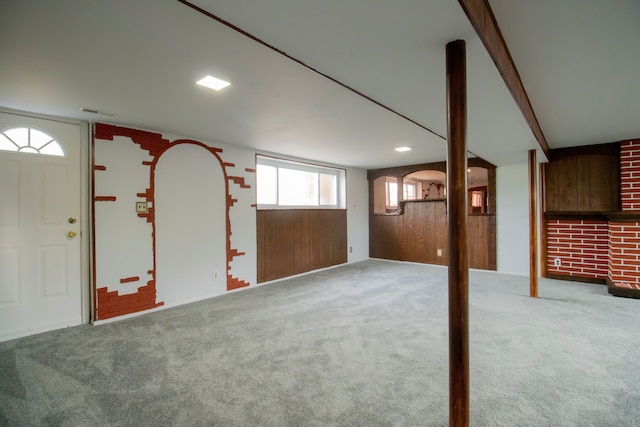 basement with carpet floors and wood walls