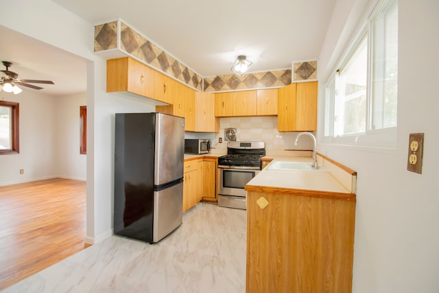 kitchen featuring tasteful backsplash, sink, a healthy amount of sunlight, and appliances with stainless steel finishes