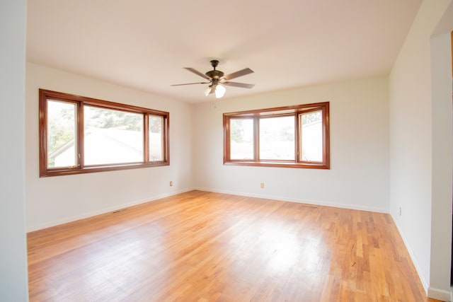 empty room with ceiling fan, light hardwood / wood-style floors, and a wealth of natural light