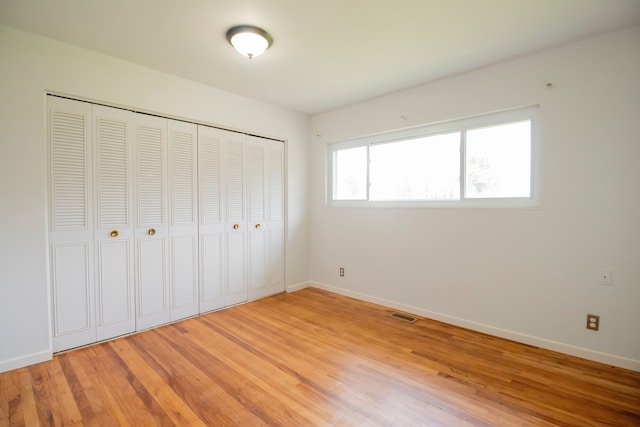 unfurnished bedroom with a closet and hardwood / wood-style floors