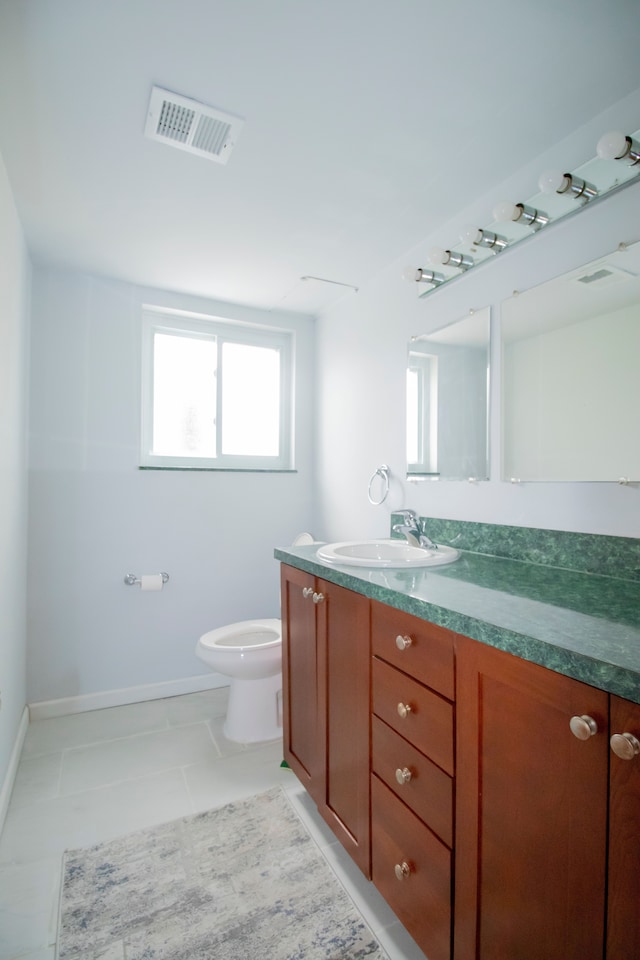 bathroom featuring tile patterned floors, vanity, and toilet