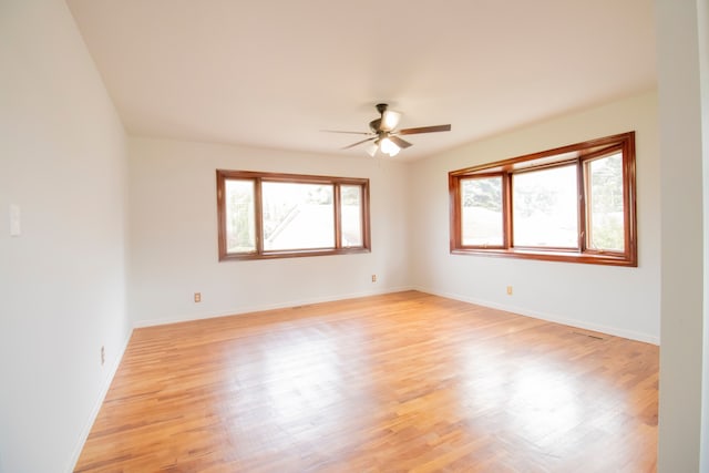 unfurnished room featuring light wood-type flooring, ceiling fan, and a healthy amount of sunlight