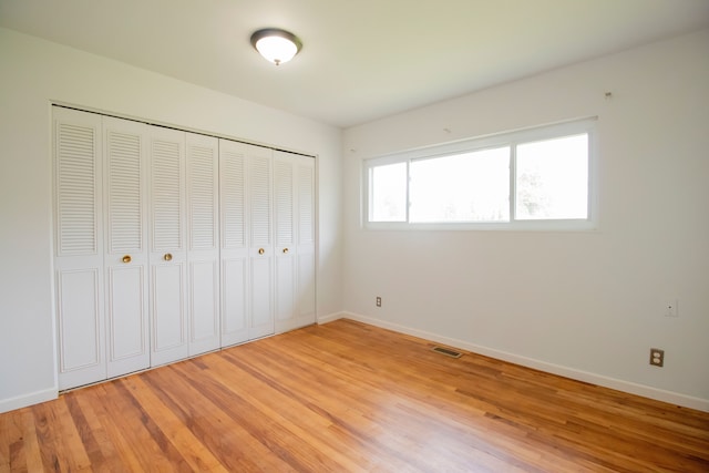 unfurnished bedroom featuring wood-type flooring and a closet