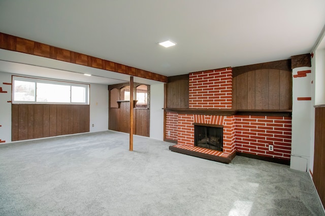 unfurnished living room with wood walls, a fireplace, and carpet