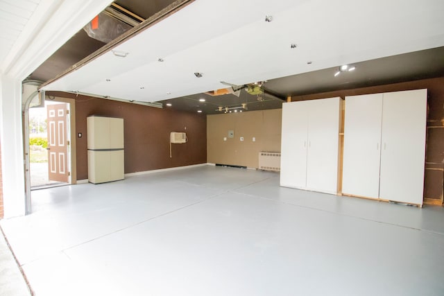 garage featuring white fridge and a wall unit AC