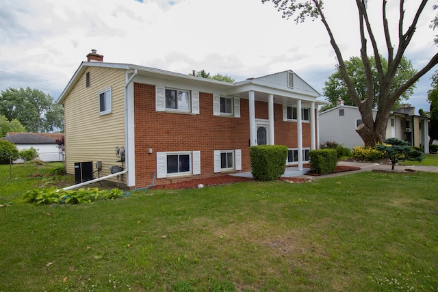 view of front of property with central air condition unit and a front yard