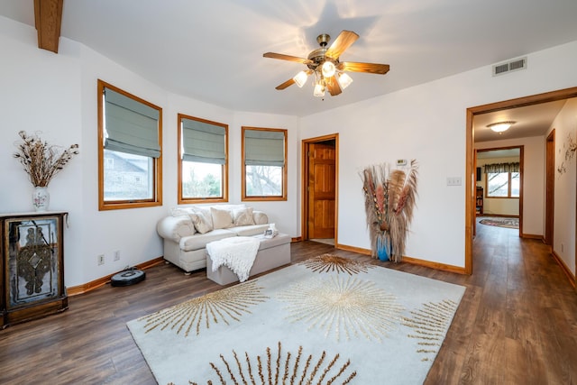 unfurnished living room with ceiling fan, dark wood-type flooring, and a healthy amount of sunlight