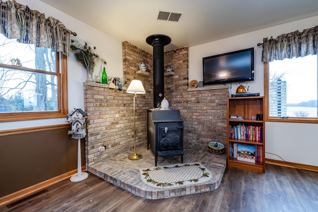 living room with hardwood / wood-style floors and a wood stove