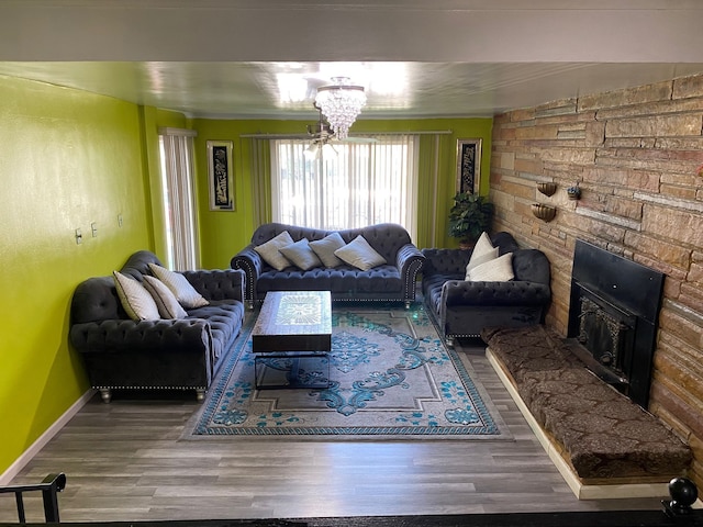 living room featuring a fireplace, a chandelier, and hardwood / wood-style flooring