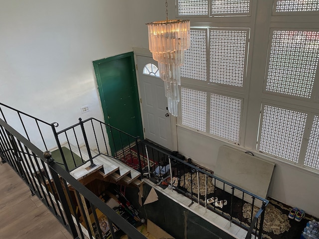 staircase with a notable chandelier and wood-type flooring