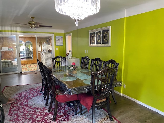 dining space featuring hardwood / wood-style floors and ceiling fan with notable chandelier