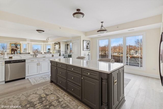 200 Lake St Unit 3B, Saint Joseph, MI 49085 - kitchen with stainless steel dishwasher, light countertops, light wood-style floors, and white cabinets