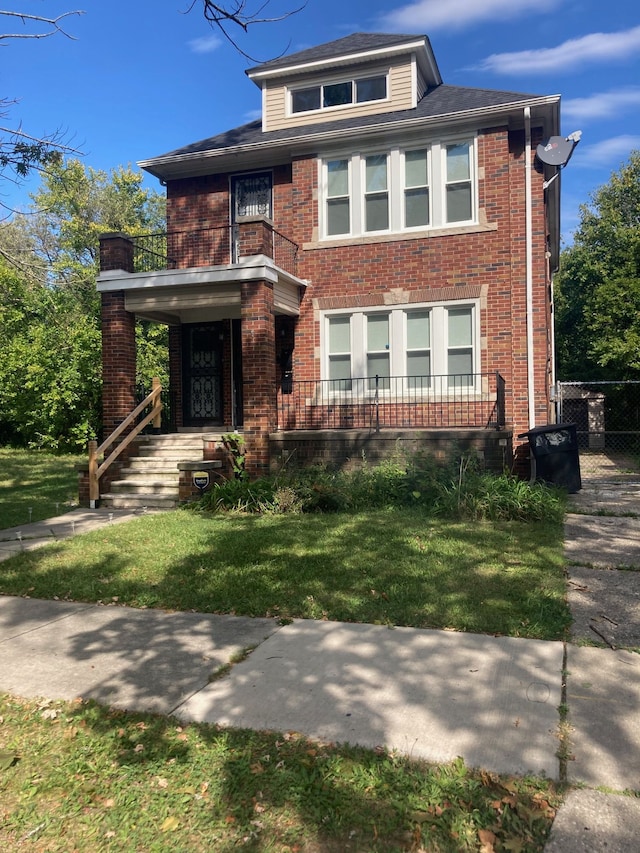 view of front of home with a balcony and a front lawn