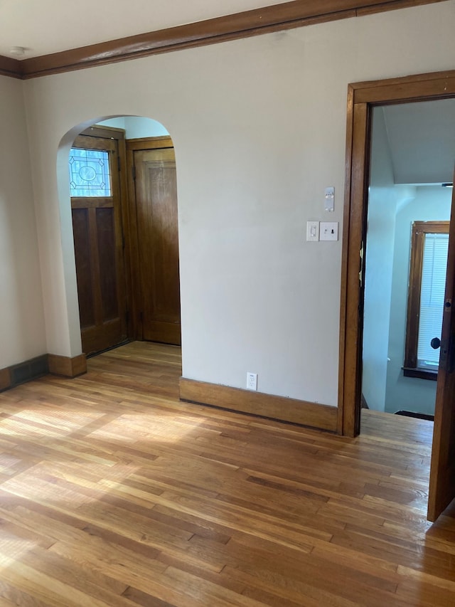 spare room with hardwood / wood-style floors and crown molding