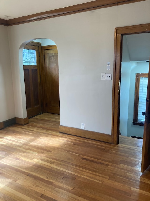 3918 Nottingham Rd, Detroit, MI 48224 - empty room with arched walkways, light wood-style floors, and ornamental molding