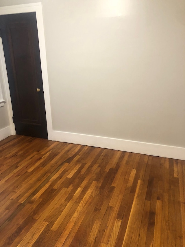 unfurnished room featuring dark wood-type flooring