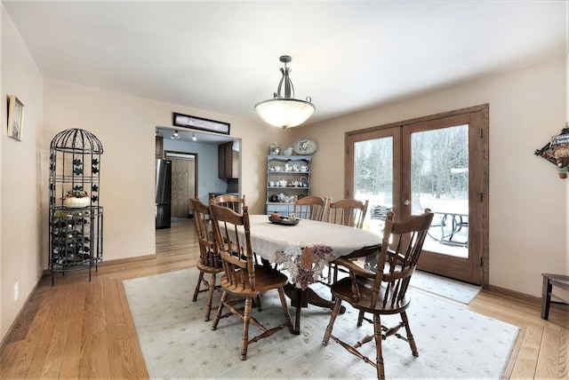 7580 River Rd, Evart, MI 49631 - dining space featuring french doors, light wood-style floors, and baseboards