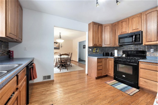 7580 River Rd, Evart, MI 49631 - kitchen with black appliances, backsplash, light wood-type flooring, and baseboards