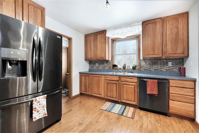 7580 River Rd, Evart, MI 49631 - kitchen with stainless steel appliances, a sink, decorative backsplash, light wood finished floors, and brown cabinetry
