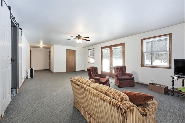 7580 River Rd, Evart, MI 49631 - living area featuring carpet, a barn door, ceiling fan, and baseboards