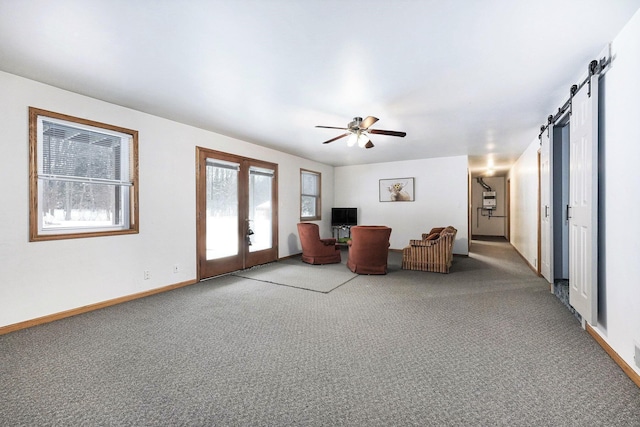 7580 River Rd, Evart, MI 49631 - living room featuring a barn door, french doors, carpet floors, and baseboards