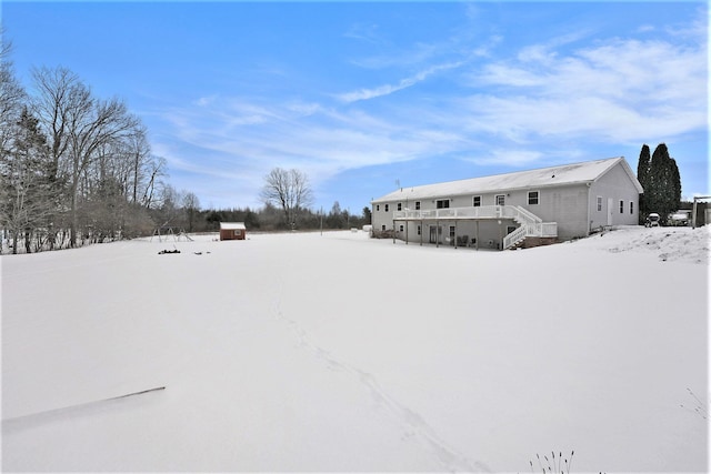 yard covered in snow with a storage shed