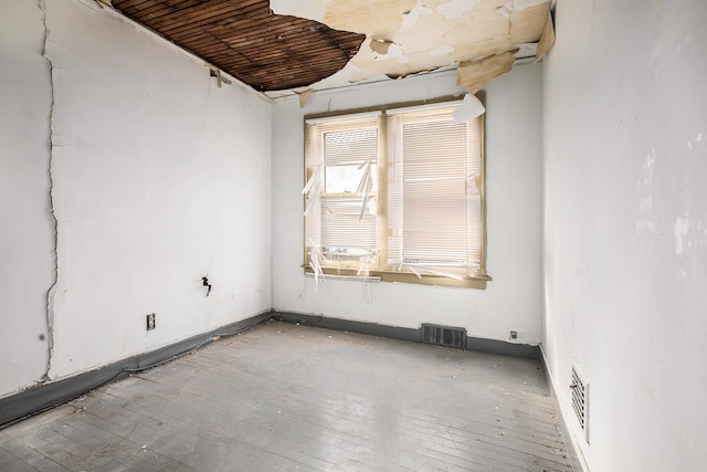 empty room featuring light wood-type flooring and wooden ceiling