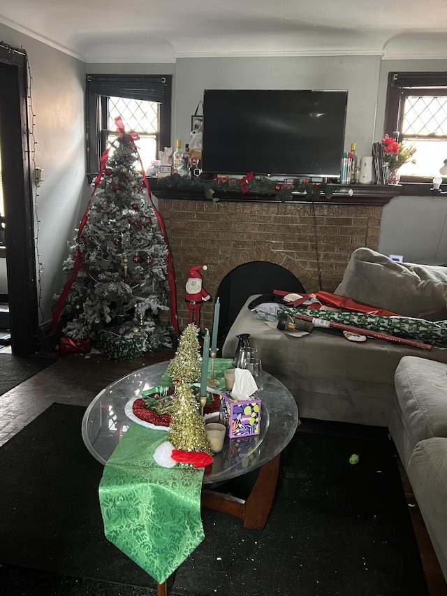 living room with a brick fireplace and ornamental molding