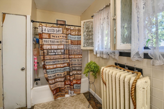 bathroom featuring shower / bath combo, radiator, lofted ceiling, and tile walls