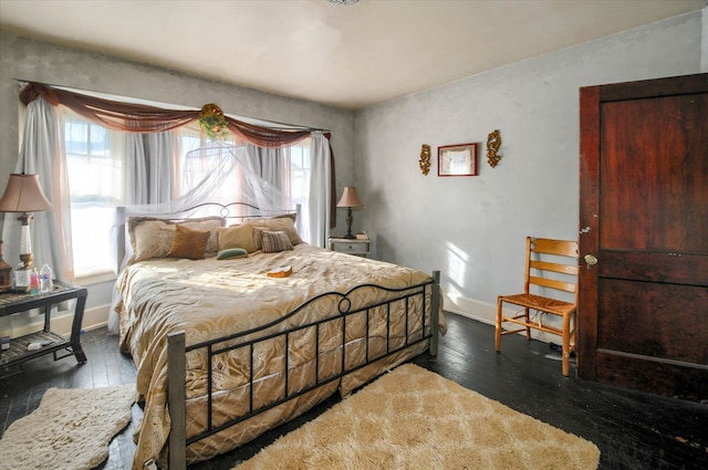 bedroom with dark hardwood / wood-style floors